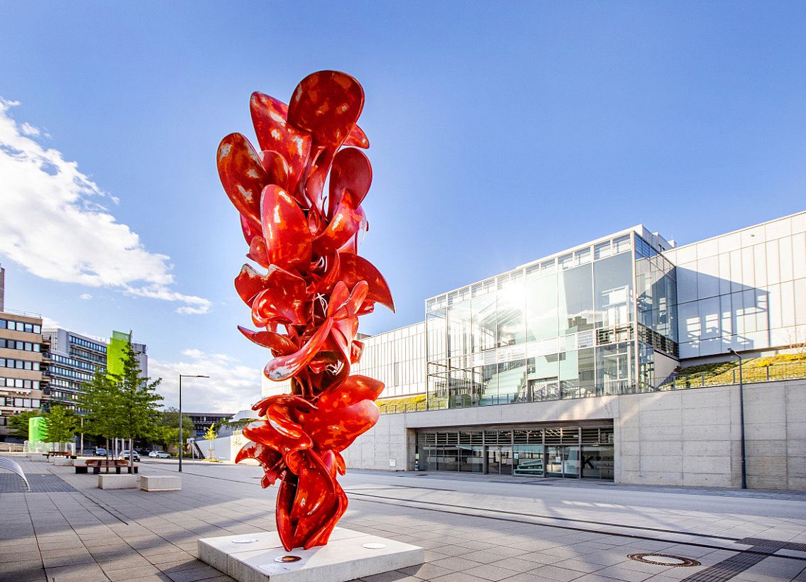 rote Skulptur von Tony Crapp vor dem Geb. V/W